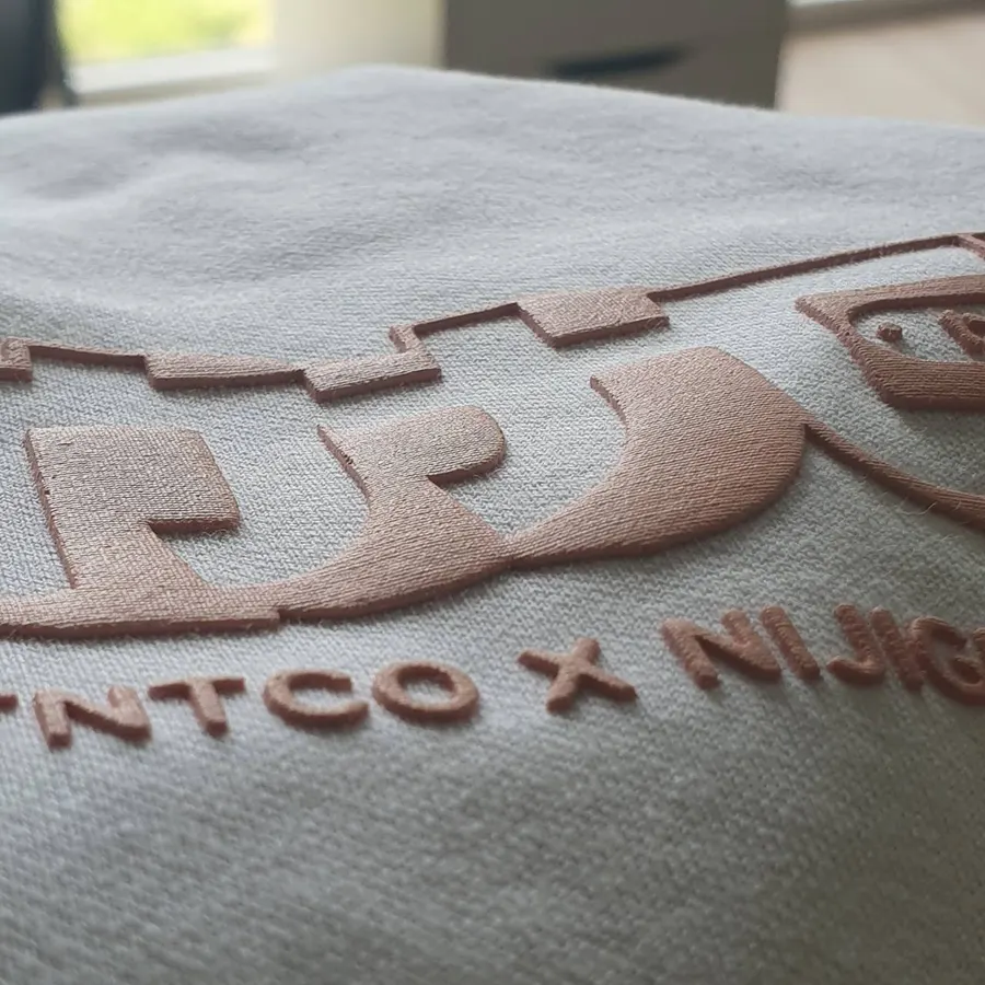 Raised pink puff print logo on a white sweatshirt, close up
